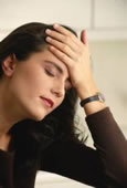 Woman experiencing headache depicting need of chiropractic treatment